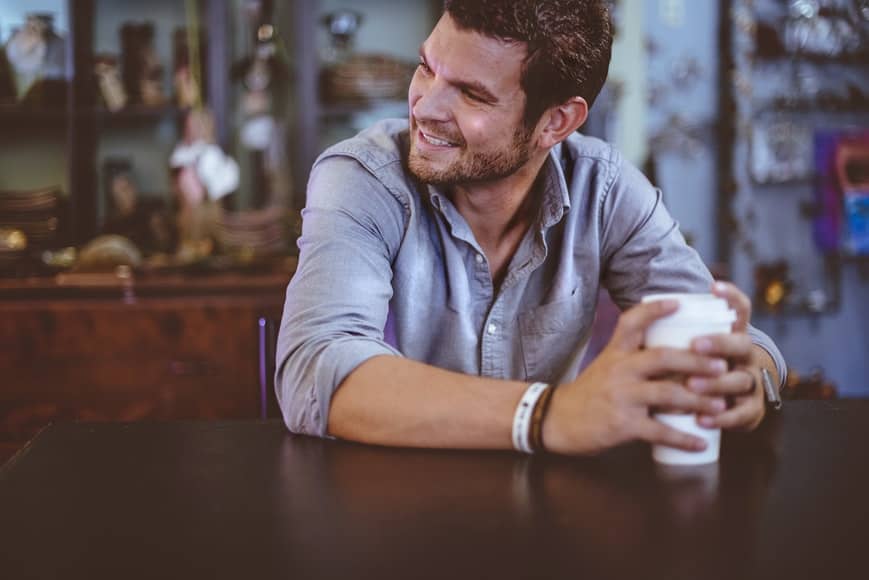 a smiling man sitting in the bar