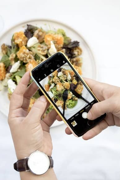 a person taking a picture of the meal on the plate 