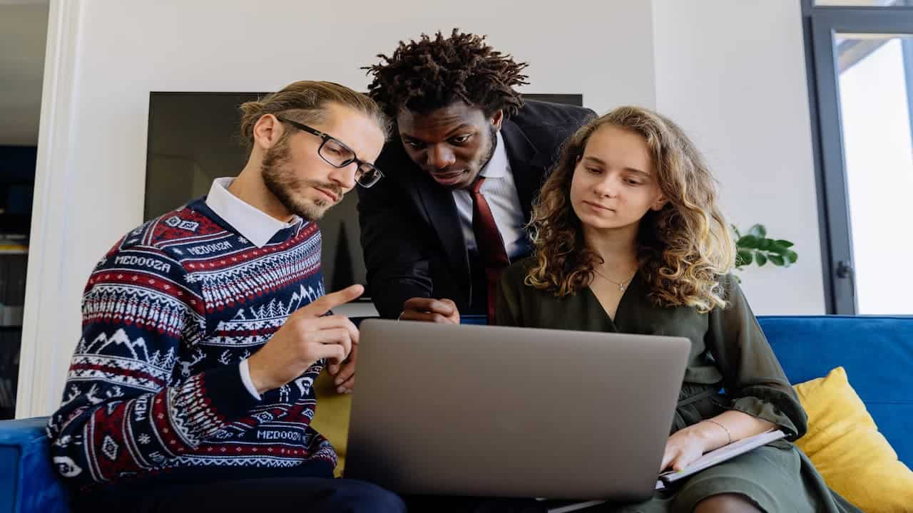 three people in front of the laptop