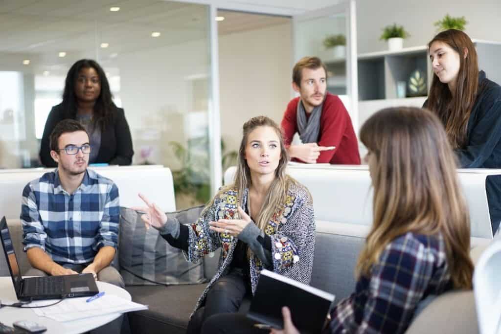 a group of people listening to a woman speaking