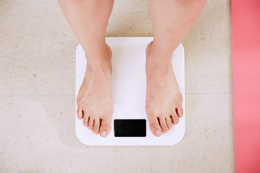 a person measuring weight on the scale