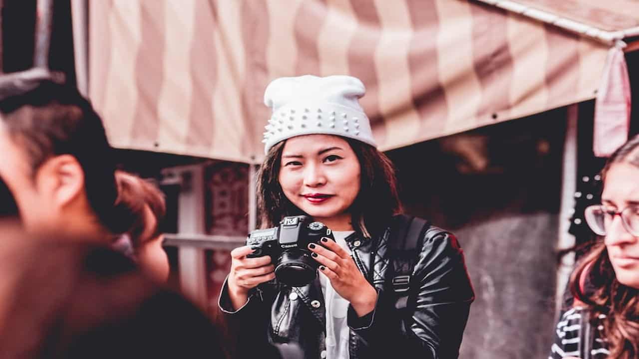 woman with a cap holding camera